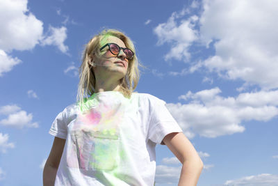 Portrait of young woman standing against sky