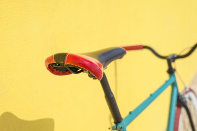 Close-up of bicycle against yellow wall