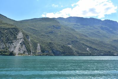 Scenic view of sea and mountains against sky