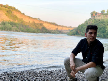 Young man sitting on land