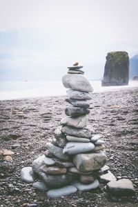 Stack of pebbles on beach against sky