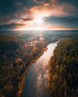 Scenic view of river in forest against sky during sunset