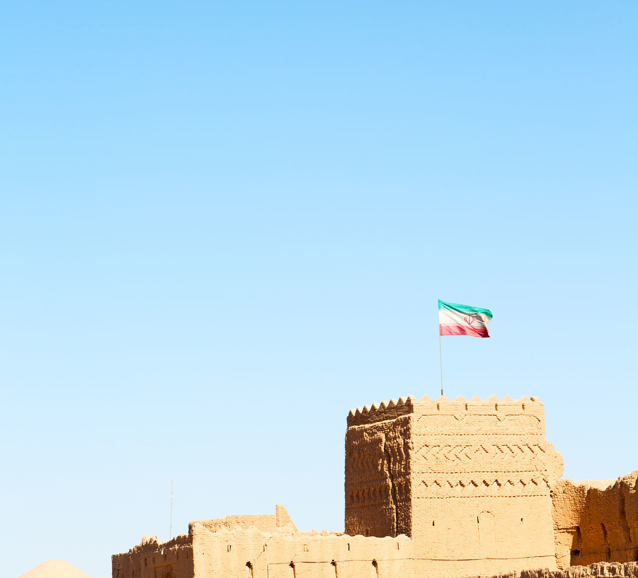 LOW ANGLE VIEW OF FLAG ON BUILDING AGAINST CLEAR SKY