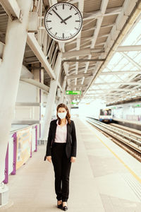 Full length of woman standing at railroad station