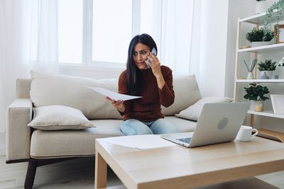 Young woman using laptop while sitting at home