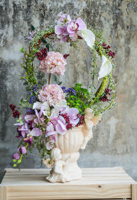 Close-up of pink flower vase against wall