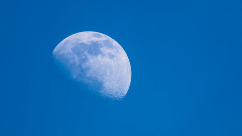 Low angle view of moon against blue sky