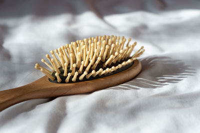 Close-up of hair brush on bed