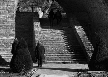 Rear view of people walking on steps