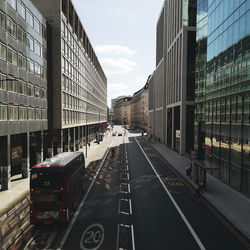 Road amidst buildings in city against sky