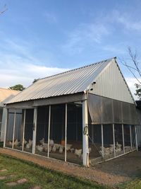 Exterior of old house on field against sky