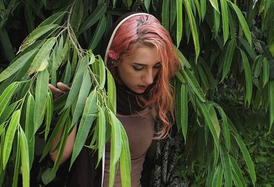 Close-up of young woman with plants in field