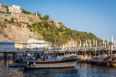 Boats moored on sea against clear sky