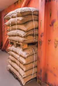 Stacked sacks by wall at warehouse