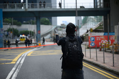 Rear view of man protesting on street in city