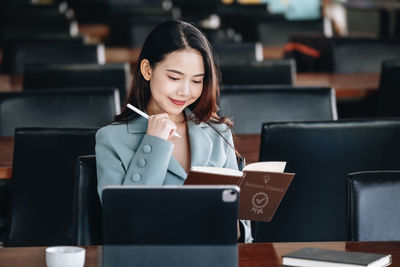 Businesswoman using laptop while sitting on table