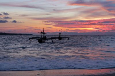 Silhouette boat in sea against sky during sunset