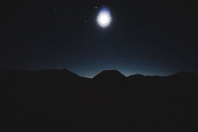 Scenic view of silhouette mountains against sky at night