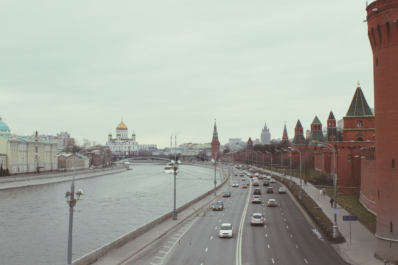 architecture, built structure, building exterior, transportation, city, road, car, sky, the way forward, street, mode of transport, land vehicle, travel, cityscape, city life, travel destinations, diminishing perspective, capital cities, bridge - man made structure, vanishing point