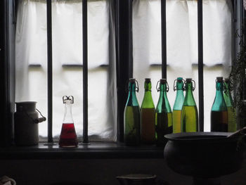 Bottles on table by window