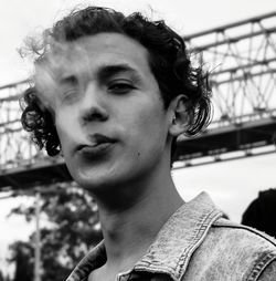 Close-up portrait of young man smoking outdoors