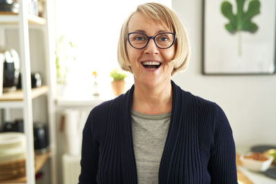 Portrait of young woman standing against wall