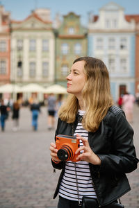 Female traveler taking picture with vintage instant camera