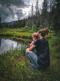 Rear view of woman and child fishing in the montana mountains