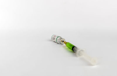 High angle view of green container on table against white background