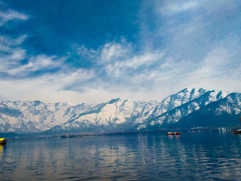 Scenic view of lake and snowcapped mountains against sky