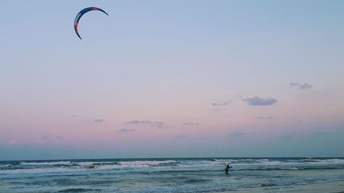 People in sea against sky