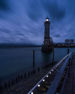 Lighthouse by sea against sky