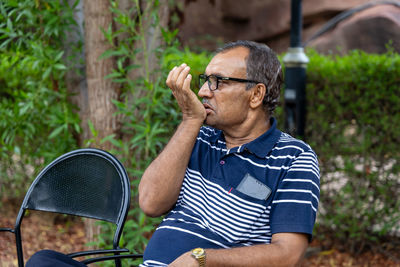 Man using tobacco closeup shot at outdoor park at evening from flat angle