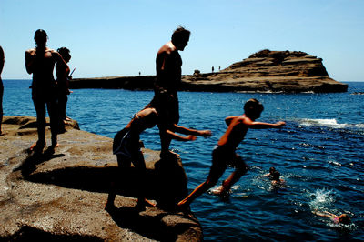 People at beach against sky