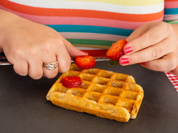 Midsection of woman holding strawberries