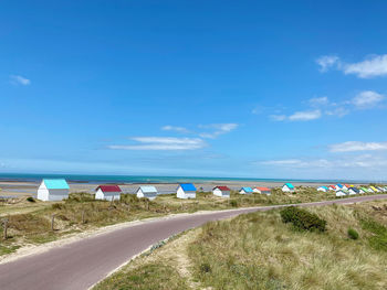 Beach behind dunes houses with colored roof green park blue sky summerhouse street multicolored 