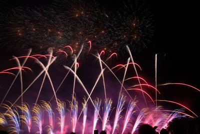 Low angle view of firework display at night