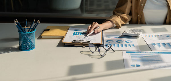 Midsection of business colleagues working on table