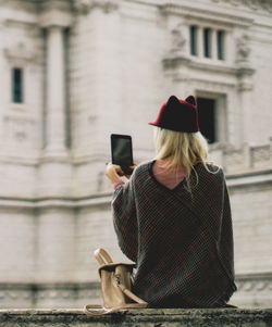 Woman photographing with mobile phone in city