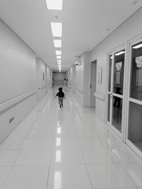 Rear view of man walking in corridor of building