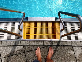 Low section of man standing at poolside