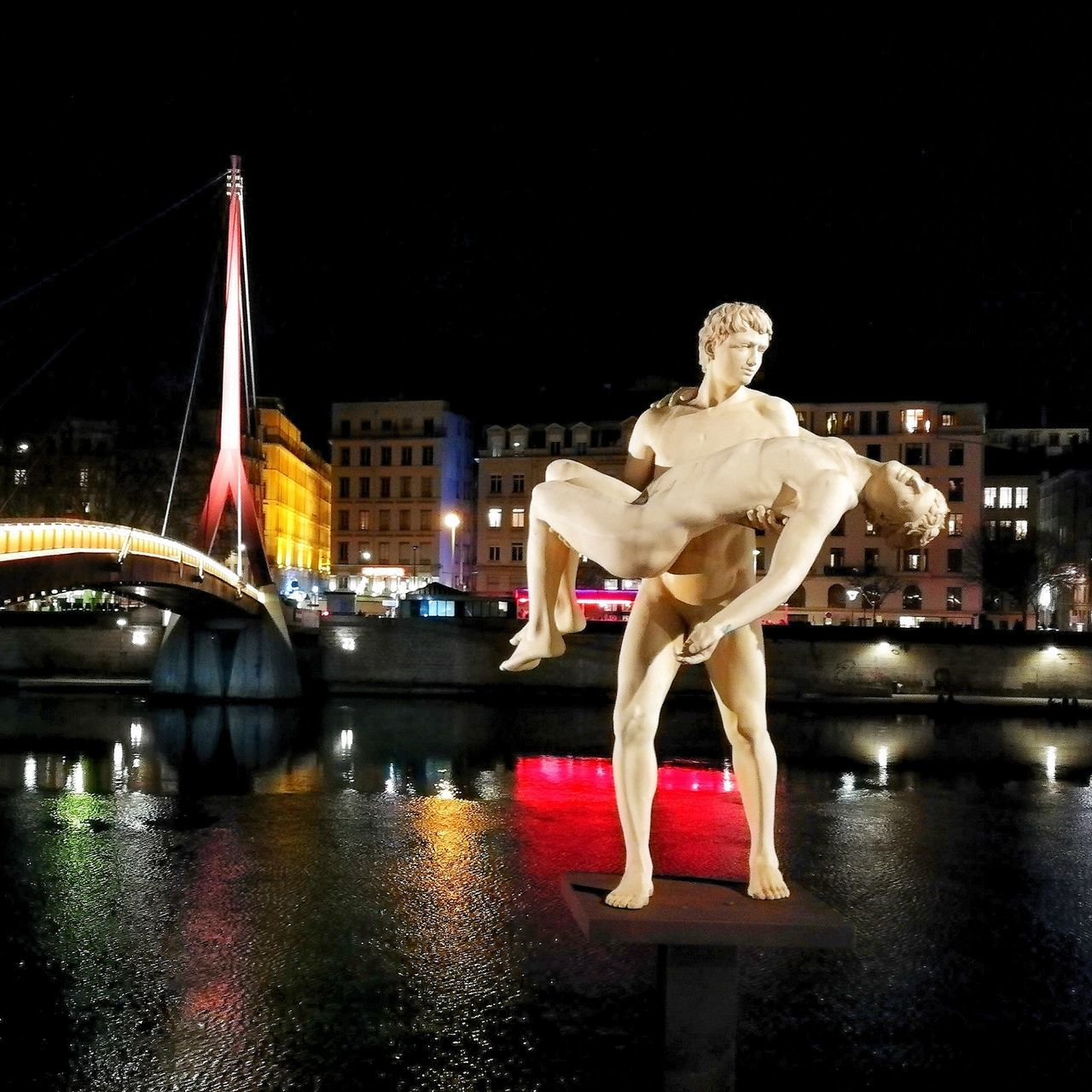 STATUE OF ILLUMINATED BRIDGE OVER RIVER IN CITY