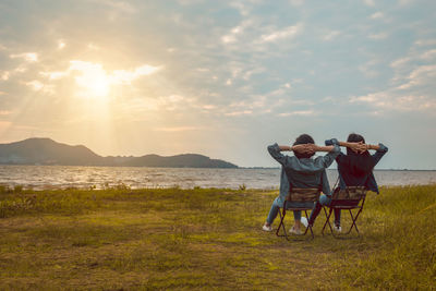 Rear view of couple on land against sky