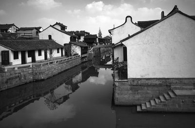 Canal amidst buildings against sky