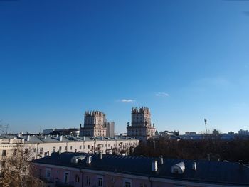 Buildings in city against blue sky