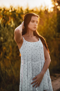 Young beautiful woman in white dress in corn field.