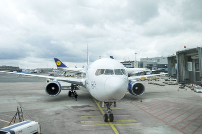 Airplane on airport runway against sky