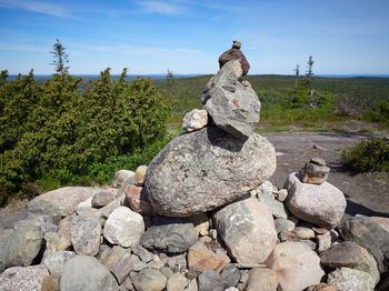 Stone stack on rock against sky