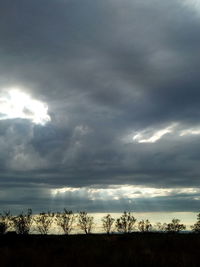 Silhouette of landscape against cloudy sky