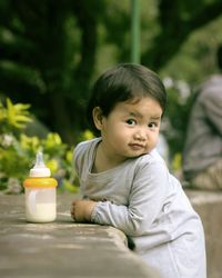 Portrait of cute baby boy sitting at park 